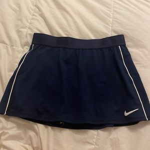 small navy blue nike tennis skirt with white stripes down the side
